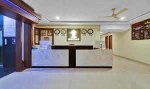 a lobby with a reception desk and clocks on the wall at Treebo Trend Tee in Hyderabad