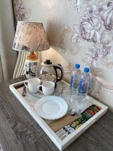 a tray with a tea pot and cups and a lamp on a table at Guest House near Kolonnady in Kislovodsk