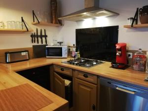 a kitchen with a stove top oven next to a microwave at Le logis du héron in Coulon +5 photos