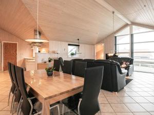 een woonkamer met een houten tafel en zwarte stoelen bij 8 person holiday home in Vinderup in Vinderup
