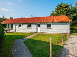 una pequeña casa blanca con techo naranja en 8 person holiday home in Odder en Odder