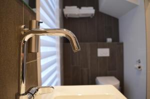 a bathroom sink with a faucet next to a toilet at Herberg Welgelegen in Katwijk +36 photos