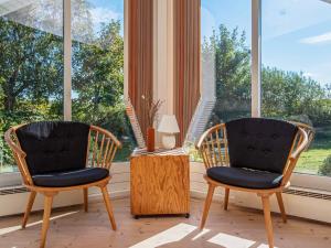 2 chaises et une table devant une fenêtre dans l'établissement 10 person holiday home in Idestrup, à Bøtø By