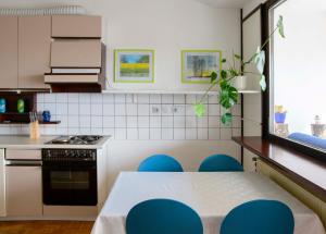 a kitchen with a table and some blue chairs at Beautiful apartment in the nicest part of town in Ljubljana