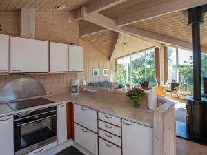 une cuisine avec des placards blancs et une grande fenêtre dans l'établissement 10 person holiday home in Idestrup, à Bøtø By