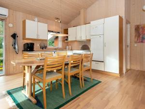 eine Küche mit einem Tisch und Stühlen sowie einem Kühlschrank in der Unterkunft Holiday home Ebeltoft CXLVIII in Ebeltoft