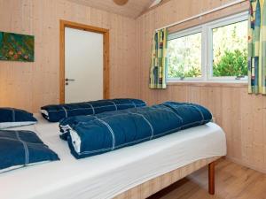 1 Schlafzimmer mit 3 Betten und blauen Kissen in der Unterkunft Holiday home Ebeltoft CXLVIII in Ebeltoft