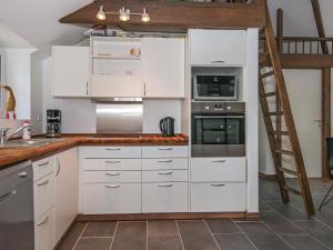 una cocina con armarios blancos y una escalera en 6 person holiday home in Ansager en Ansager