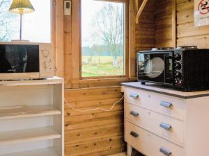 a kitchen with a microwave on top of a dresser at 4 person holiday home in SANDHEM in Sandhem
