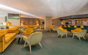 a hotel lobby with yellow furniture and a bar at HF Ipanema Park in Porto
