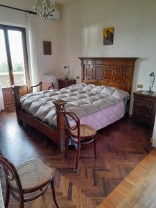 een slaapkamer met een groot bed en 2 stoelen bij Lovely place in Passignano sul Trasimeno