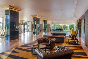 a lobby with leather furniture and a piano at HF Ipanema Park in Porto