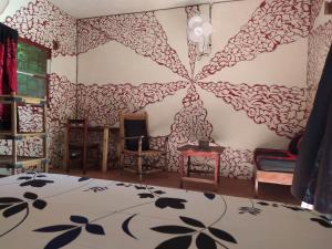 ein Wohnzimmer mit einer Wand mit Blumenmuster in der Unterkunft Chez Yaya - Grande Chambre in Oussouye