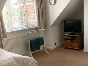 a bedroom with a bed and a television on a dresser at 83 in Aylesbury