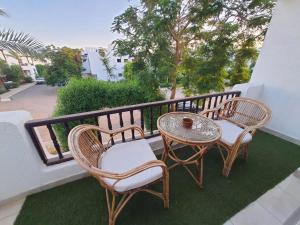 a patio with two chairs and a table on a balcony at Delta Sharm Apartments with free Internet Wi-Fi in Sharm El Sheikh