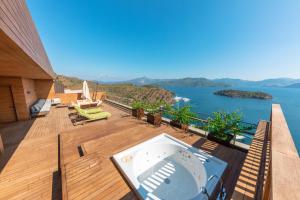 een balkon met een hot tub en uitzicht op het water bij D Maris Bay in Hisarönü