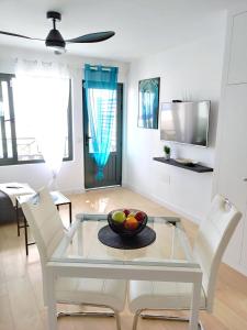 a dining room with a glass table and white chairs at Apartment Portonovo Paraiso II - Sea View - Piscina - Wifi - Old Town in Puerto del Carmen