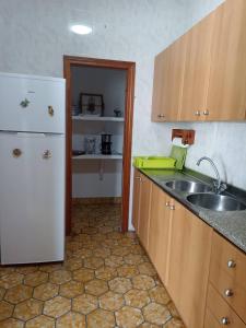 una cucina con frigorifero bianco e lavandino di Houpla Porto Cristo a Porto Cristo
