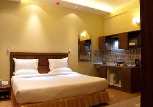 a bedroom with a large bed and a kitchen at UDS Villa Scandinavian B&B - Next to VFS in New Delhi