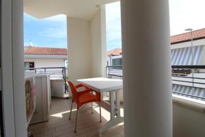 a balcony with a white table and a chair at Solemare in Tortoreto Lido +10 photos