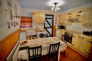 a kitchen with a table and chairs and a kitchen with wooden cabinets at Victoria Titanic 1912 cottage in Belfast