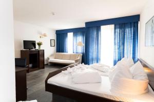 a hotel room with a bed and a living room at Hotel Astoria am Urachplatz in Stuttgart