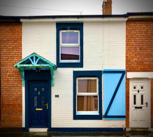 a brick house with blue doors and windows at Victoria Titanic 1912 holiday home in Belfast