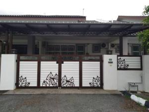 a house with a gate and a garage at Embon Homestay in Padang Serai