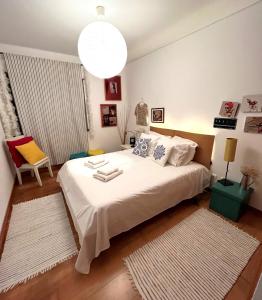 a bedroom with a large white bed and a large light fixture at epicenter SKYBAR in Lagoa