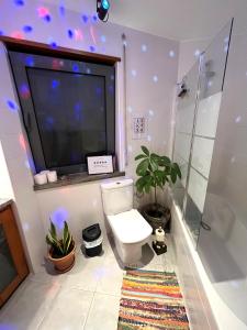 a bathroom with a toilet and a large tv at epicenter SKYBAR in Lagoa