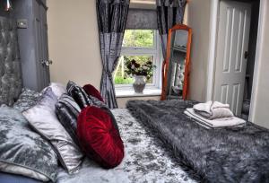a bedroom with a bed with red pillows and a window at Peniarth arms in Llanegryn
