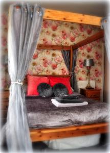 a bedroom with a canopy bed with red pillows at Peniarth arms in Llanegryn