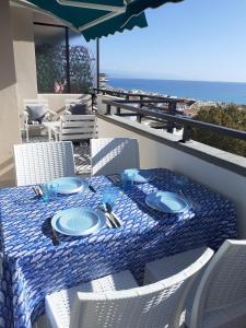 uma mesa com pratos e utensílios numa varanda com o oceano em Great views terrace apartment em Torremolinos