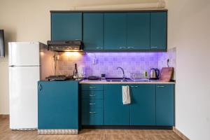 una cucina con armadi blu e frigorifero bianco di The Teal Studio in Kozani a Kozani
