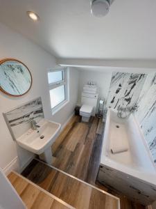 a bathroom with a sink and a tub and a toilet at Pier Plain By The Sea in Gorleston-on-Sea