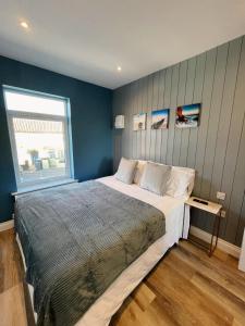 een slaapkamer met een groot bed en een raam bij Pier Plain By The Sea in Gorleston-on-Sea