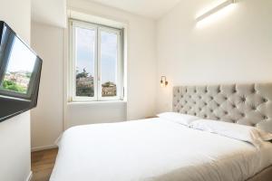 a white bedroom with a bed and a window at Contempora Apartments - Turati 3 One Bedroom Apartment in Milan