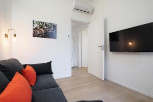 a living room with a couch and a flat screen tv at Contempora Apartments - Turati 3 One Bedroom Apartment in Milan