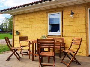 une table et des chaises en bois sur une terrasse dans l'établissement 4 person holiday home in SANDHEM, à Sandhem