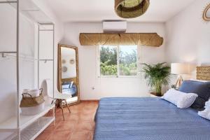 a bedroom with a blue bed and a mirror at THE LOVELY VILLA IBIZA in Ibiza Town