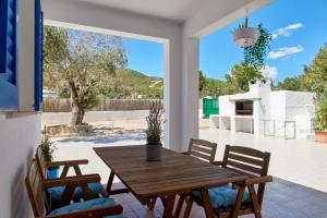 ein Esszimmer mit einem Holztisch und 2 Stühlen in der Unterkunft THE LOVELY VILLA IBIZA in Ibiza-Stadt