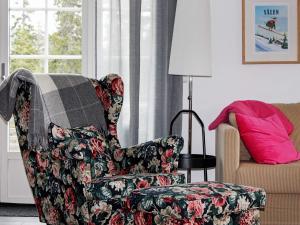 a living room with a chair and a pink pillow at 7 person holiday home in S LEN in Sälen