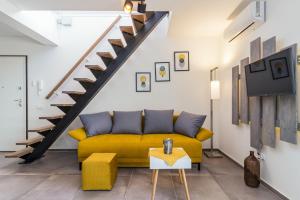 - un salon avec un canapé jaune et des escaliers dans l'établissement Penthouse Apartment Sax, à Medulin