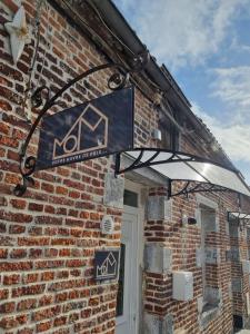 een bord aan de zijkant van een bakstenen gebouw bij KASA MOM - Votre Havre de paix in Saint-Aybert