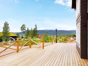 een houten terras met een hek en bergen op de achtergrond bij Holiday home SÄLEN XXV in Stöten