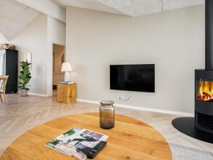 ein Wohnzimmer mit einem Kamin und einem TV in der Unterkunft Holiday home Hjørring XXXVI in Hjørring