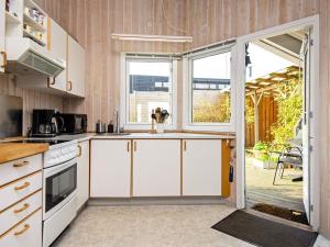 a kitchen with white cabinets and a large window at 6 person holiday home in Børkop-By Traum in Børkop