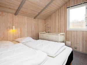 two beds in a room with wooden walls and a window at 6 person holiday home in Børkop-By Traum in Børkop