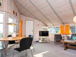 a living room with a table and chairs and a television at 6 person holiday home in Børkop-By Traum in Børkop