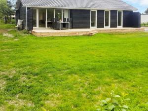 uma casa com um relvado verde em frente em 8 person holiday home in Hadsund em Hadsund